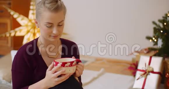 体贴的女人坐在家里喝杯咖啡视频的预览图