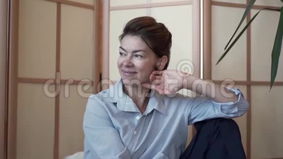 一幅优雅衣着考究成熟的女士与坐在房间里的朋友交谈的肖像带有现代设计那个女人视频的预览图