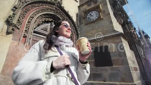 微笑的旅行女性欣赏建筑喝咖啡纸杯中型特写视频的预览图
