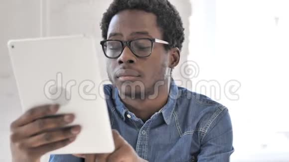 创意非洲男人在平板电脑上浏览互联网视频的预览图