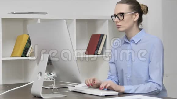 头痛疲惫的年轻休闲女孩在电脑上工作视频的预览图