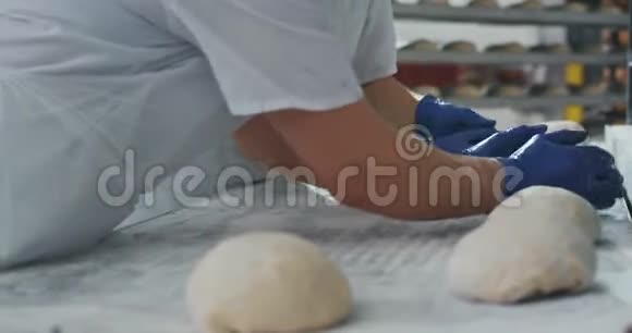 专业面包师用面团制作面包在商业面包店的厨房里烤面包视频的预览图