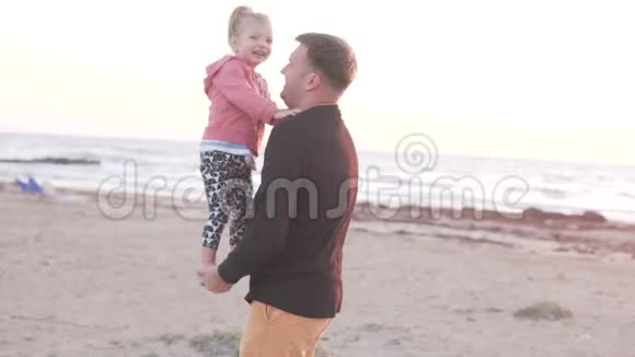爸爸在海滩上和一个小女孩玩视频的预览图