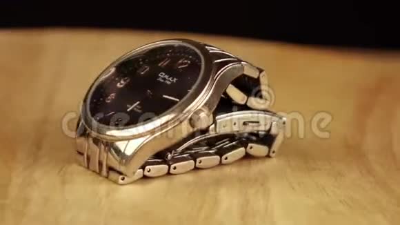 银色的机械手表在木制平台上旋转360度视频的预览图