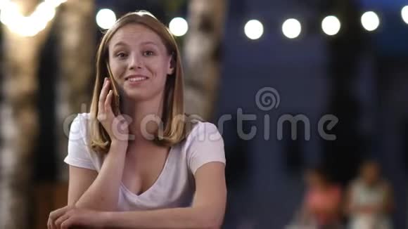 漂亮的女孩在外面的咖啡馆里打电话视频的预览图