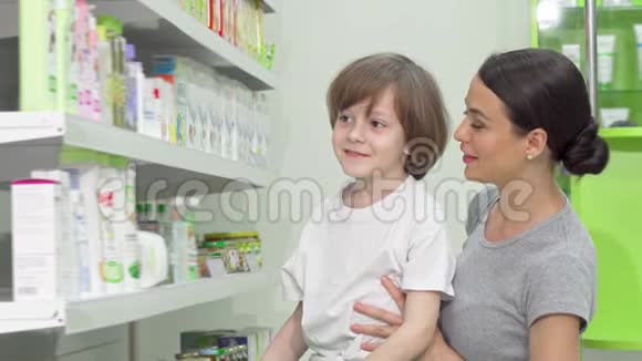美丽的女人和她的小儿子正在检查药房出售的产品视频的预览图