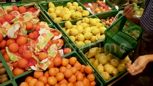 女手在超市里摘橘子女人从超市的盒子里拿水果视频的预览图