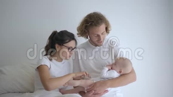 幸福的家庭快乐的微笑的女性男性抱着小新生的女孩享受着妇产医院的乐趣视频的预览图