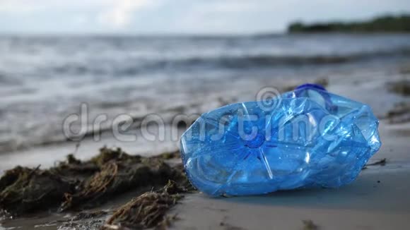 海边有一个塑料瓶海浪拍打着海岸污染的海滩4K慢慢视频的预览图