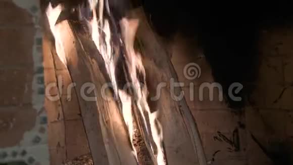 一堆木头烧在砖壁炉里黄色和紫色火焰的舌头视频的预览图