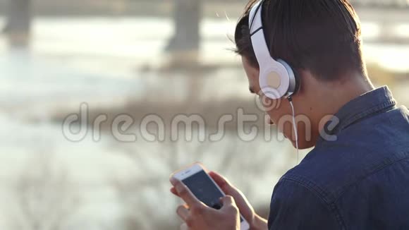 一个十几岁的男孩用耳机听音乐的特写镜头视频的预览图