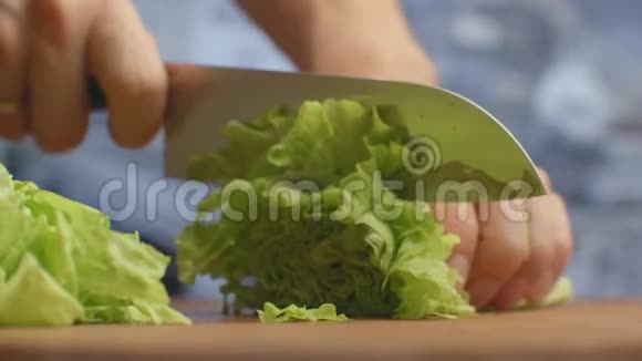 在木板特写上剪生菜叶切碎视频的预览图