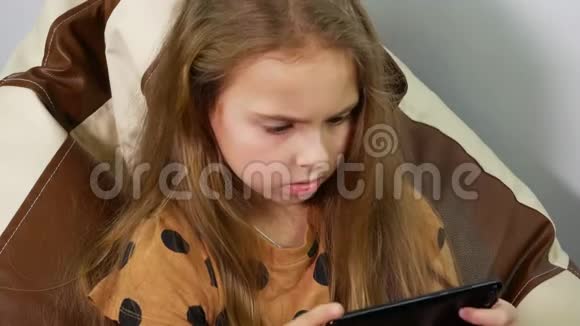 青少年阅读信息的焦虑表情把9岁的女孩用智能手机视频的预览图