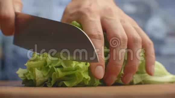 在木板特写上剪生菜叶切碎视频的预览图