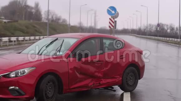 下雨期间道路上发生车祸红色损坏的汽车在一条空路上视频的预览图