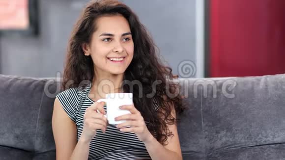 可爱的西班牙家庭女孩微笑着喝咖啡在家放松视频的预览图