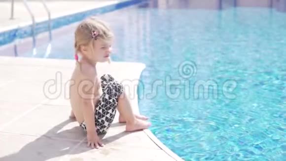 一个漂亮的小女孩坐在池边着腿视频的预览图