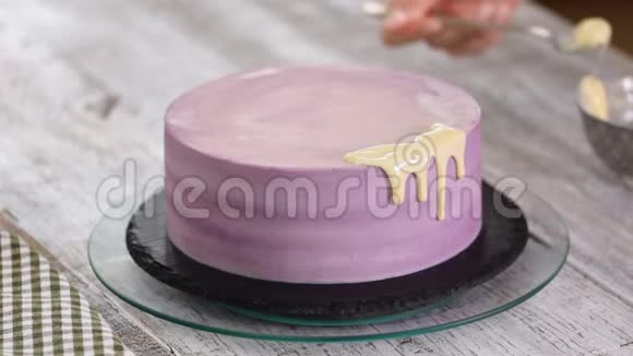 双手糕点厨师准备一个蛋糕将白巧克力釉倒在蛋糕上视频的预览图