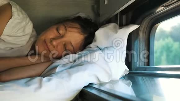 夏天女人在火车的第二个架子上睡觉窗户开着视频的预览图