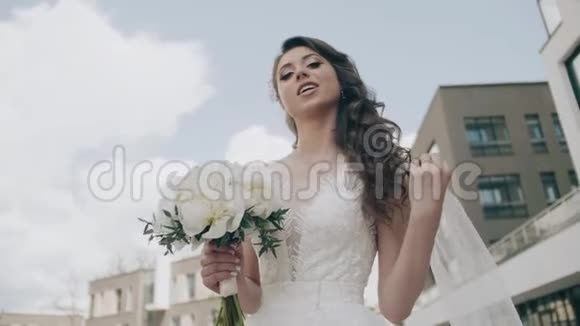 新娘风骚地躲在婚礼花束后面漂亮的女孩关门了视频的预览图