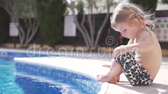 可爱的小女孩坐在泳池边微笑视频的预览图