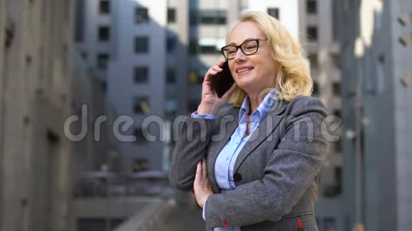 开朗的女经理站在外面打电话客户沟通视频的预览图