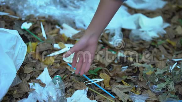 女性手拿垃圾填埋场的塑料瓶废物回收项目视频的预览图