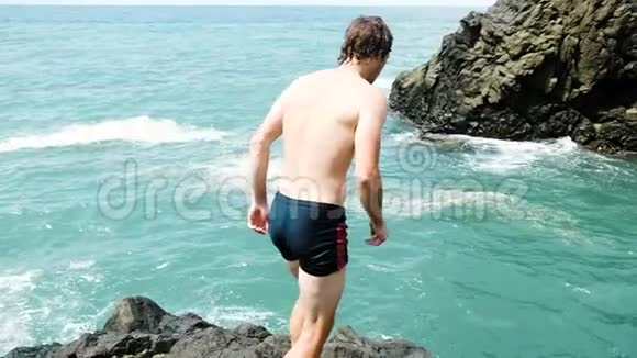 人从悬崖上缓慢地跳入大海在暑假玩得开心视频的预览图