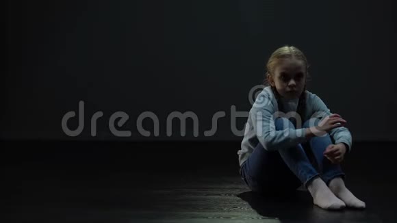 害怕的小女孩独自坐在黑暗的房间里孤独和欺凌的概念视频的预览图
