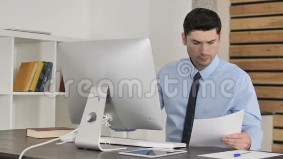 文书工作青年商人阅读文件及电脑工作视频的预览图