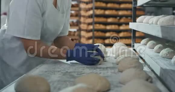 在面包店商业厨房里快速烘焙师在烤箱里用面团烘焙面包视频的预览图