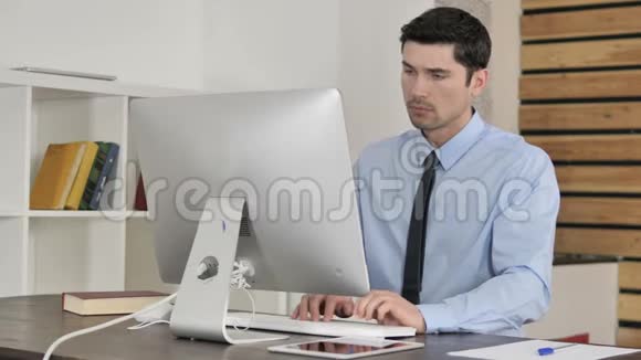 颈部疼痛的年轻商人在电脑上工作肌肉拉力视频的预览图