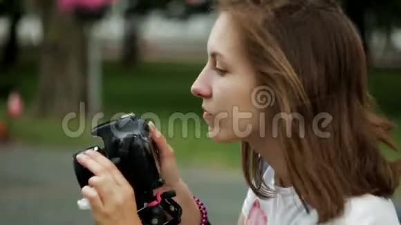 摄影师女孩夏天拍照看着照片笑视频的预览图