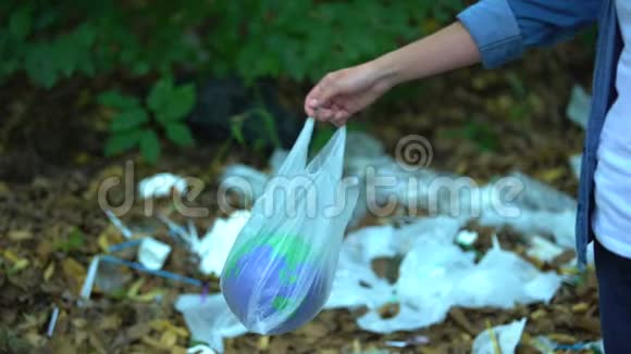粗心的女人把行星玩具装在塑料袋里扔到垃圾填埋场回收利用视频的预览图