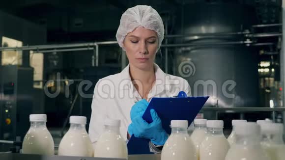 工厂工人检查传送带上的奶瓶视频的预览图
