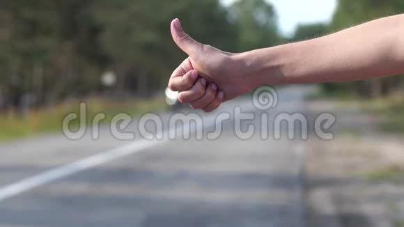 道路一个女人正试图阻止一辆路过的汽车出现在框架中的手的特写4K慢慢视频的预览图