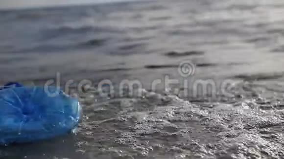 特写镜头环境污染一个塑料瓶漂浮在海岸上4K慢慢视频的预览图