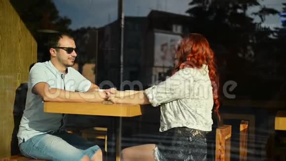 年轻的好夫妇坐在咖啡馆里裹着舒适的毯子喝茶一个女孩和一个男孩的爱情故事男子和妇女视频的预览图