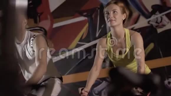 运动的男人和运动的女人一起用固定自行车视频的预览图