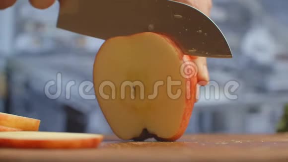 在厨房的木板上剪一把刀特写红苹果切碎视频的预览图