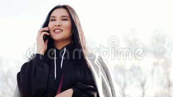 美丽的年轻亚洲女孩留着长长的黑发在智能手机上说话视频的预览图