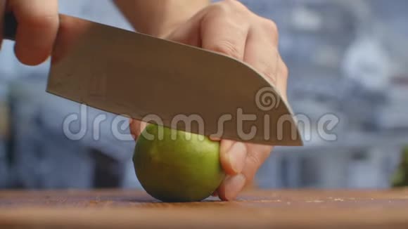 用刀子在厨房里的木板上剪下绿色石灰切碎视频的预览图