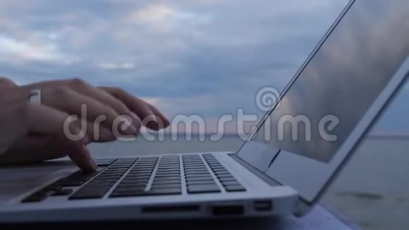 特写镜头一个女人正在键盘上打字背景是大海4K慢慢视频的预览图