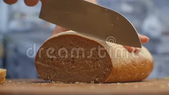 在厨房的木板特写上用刀切面包切碎视频的预览图