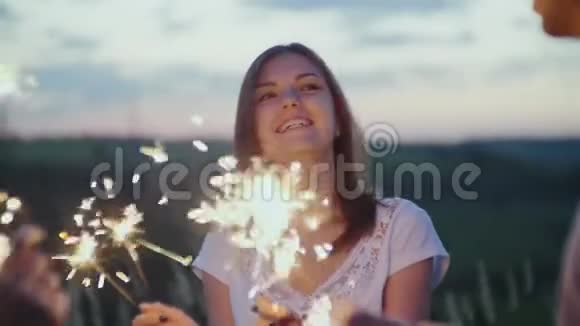 一对年轻夫妇玩烟火烟火在他们手中燃烧视频的预览图