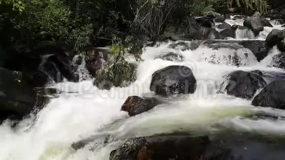 暴风雨般美丽的满溢的河流在山上石头石头木头穿过河流穿过原木和一根绳子伸展开来视频的预览图