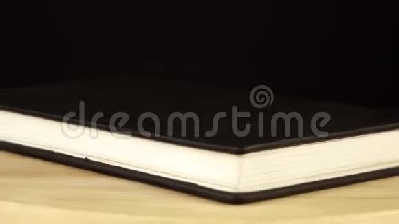 黑色笔记本在木制平台上旋转360度视频的预览图