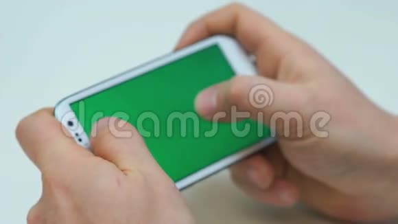 两只手拿着白色智能手机玩游戏视频的预览图