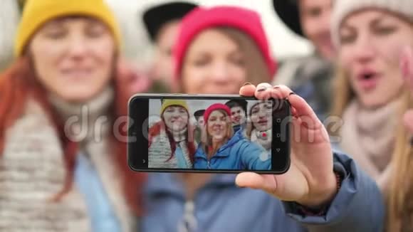 一群年轻的时髦朋友用智能手机相机自拍秋天森林的背景视频的预览图