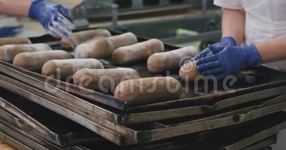 糖果厂的面包店工人把面团放在托盘上用工业烤箱烘焙面包视频的预览图